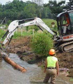 backhoe cleaning a stream