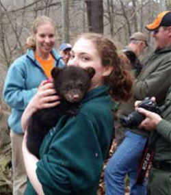 girl holding a baby bear in support of the Wildlife Scholarship Fund